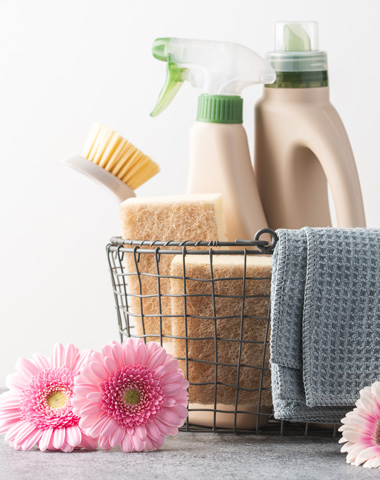 Brushes, sponges, cleaning cloth and natural cleaning products in a basket